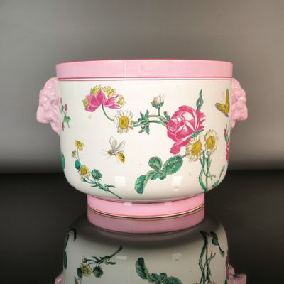 a white bowl with a pink handle and flowers on it