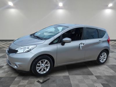 une Nissan Versa argentée garée sur un sol en dalles à damier