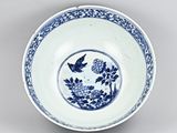 blue and white plate with a bird and flowers on it