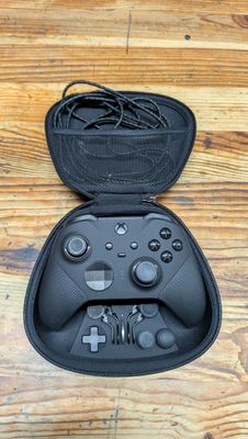 a close up of a nintendo wii controller in a case on a wooden floor
