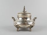 an antique silver plated teapot with a lid and two legs