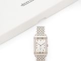 une photo d'une montre-bracelet argentée posée à côté d'une boîte blanche