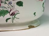 a white bowl with pink flowers on it on a table