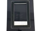 framed photograph of a black picture frame with a note on it