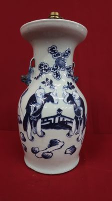 un vase bleu et blanc posé sur une surface rouge