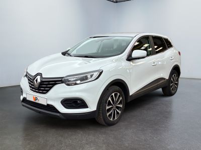 Une voiture blanche est garée dans une pièce équipée d'un ventilateur de plafond