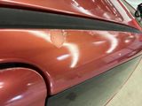 a close up of a red car in a garage
