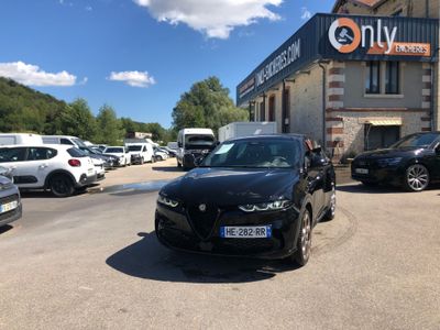 a black car parked in front of a building in a parking lot