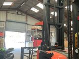 a forklift in a warehouse with a motorcycle in the background