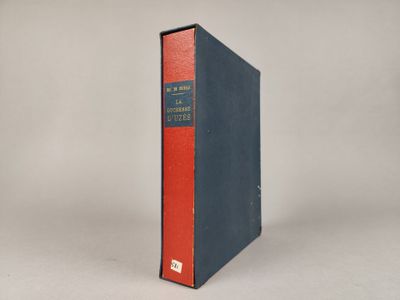 un vieux livre posé sur une table à côté d'un mur blanc