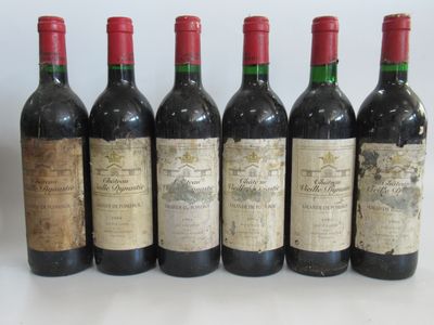 six bouteilles de vin sont alignées sur une table
