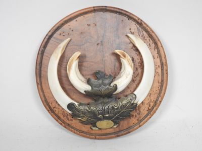 une plaque en bois sur laquelle sont représentés deux cornes et un oiseau