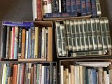 several boxes of books are stacked on the floor in front of a chair