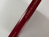 a book with a red cover sitting on top of a white table