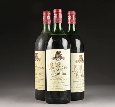 trois bouteilles de vin rouge posées sur une table