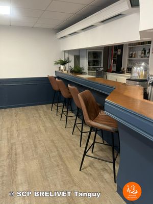 une photo d'un restaurant avec un bar et des chaises