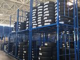 a large amount of tires are stacked on a rack in a warehouse