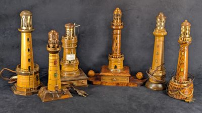 Plusieurs phares en bois s'alignent sur un fond noir