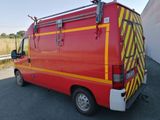 a red van with yellow stripes parked in a parking lot