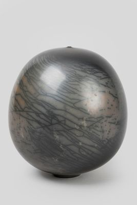 une image représentant un vase en noir et blanc posé sur une surface blanche