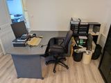 un bureau avec un ordinateur et une chaise dans une pièce