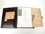 un livre ouvert sur une table, avec un stylo et du papier