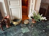 un vase de fleurs posé sur un sol en marbre, à côté d'une chaise