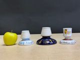 three cups and an apple sitting on a table