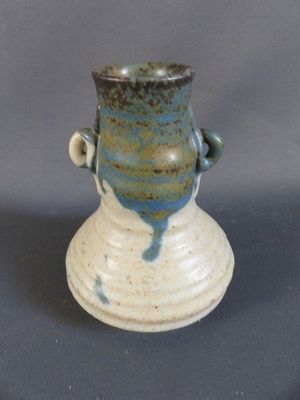 un vase bleu et blanc posé sur une surface grise