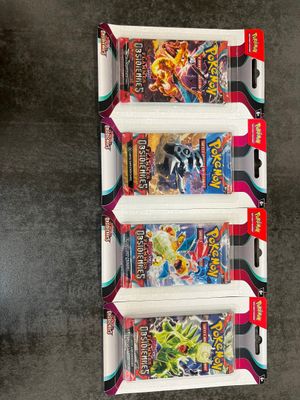 three packs of pokemon trading cards are on display in a box