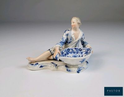 une figurine représentant une femme assise par terre avec un bol