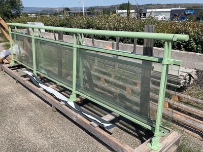 une clôture verte installée au bord de la route