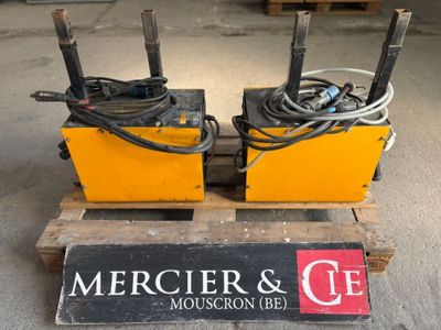 pair of electric welding equipment sitting on a pallet in a warehouse