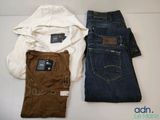 two pairs of jeans and a hoodie on a white table