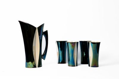 trois vases noirs et blancs posés les uns à côté des autres sur une surface blanche