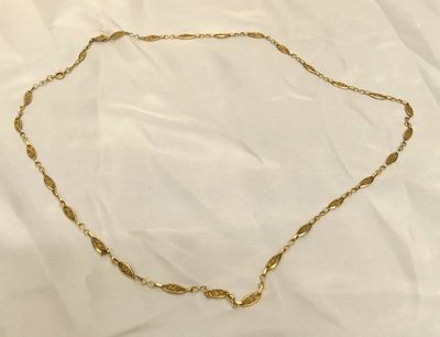 un collier en or dont la chaîne comporte un nœud