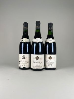 trois bouteilles de vin sont alignées sur une table