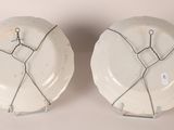 two white plates with wire wrapped around them on a table