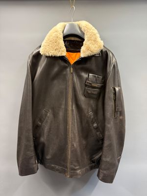 an image of a brown leather jacket hanging on a hanger