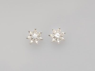 a pair of diamond earrings on a white background