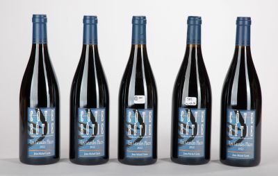 quatre bouteilles de vin sont alignées sur une surface blanche
