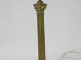 an antique brass table lamp with a candle holder on top of it