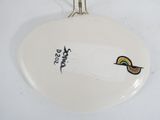 a white plate with a bird on top of it