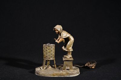 bronze figurine of a woman working on a lamp