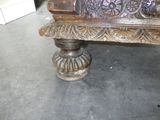 a wooden bench with carvings on it in a room