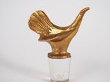 un vase en verre surmonté d'un oiseau doré