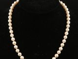 un collier de perles blanches sur un mannequin noir