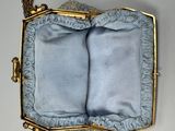 a gold purse with a blue lining and a banana next to it