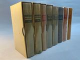six books are lined up in a row on a white surface