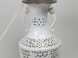 une image représentant un vase blanc surmonté d'un couvercle en bois